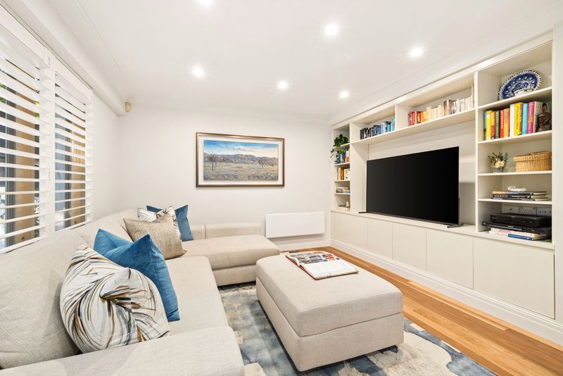 Casual living room with a large sectional sofa and wall-to-wall white joinery